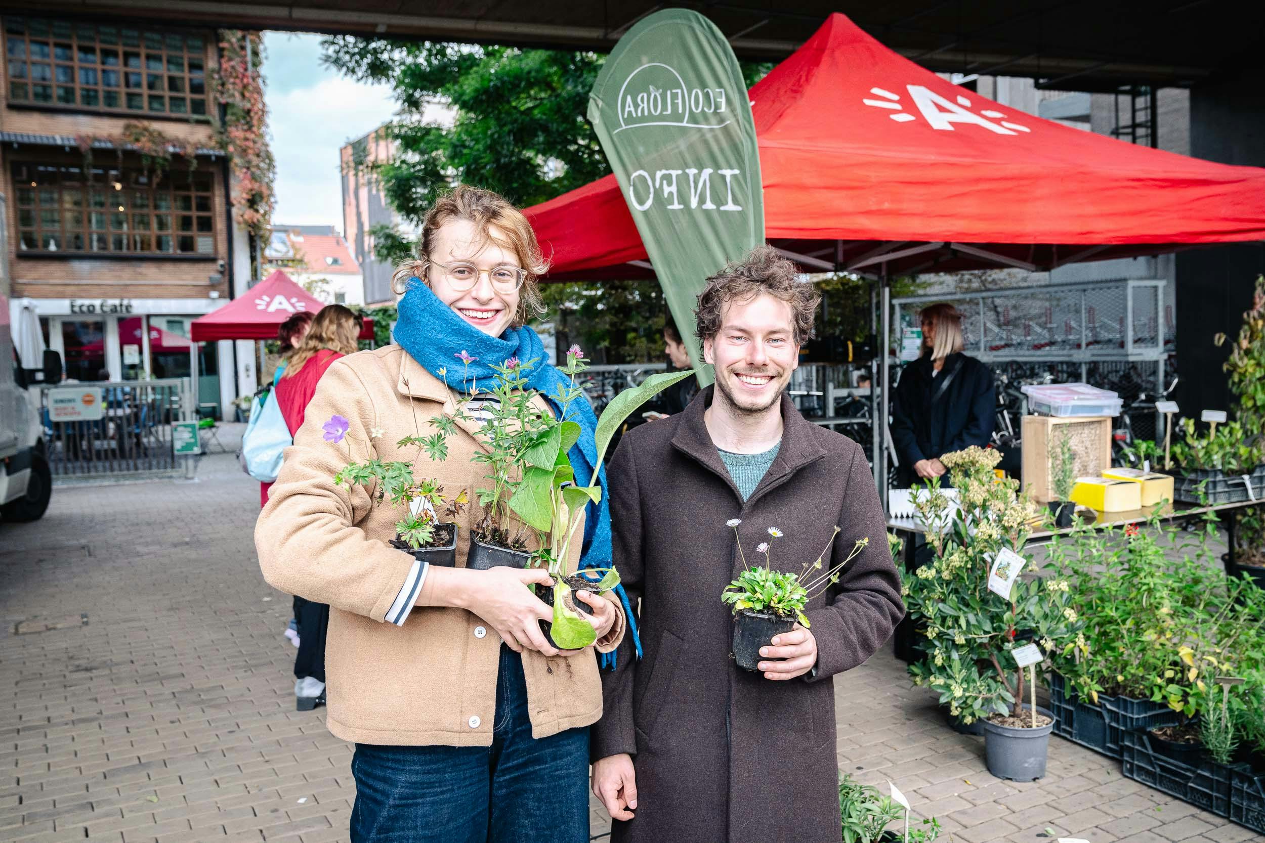 Mensen met plantjes op een feestelijk plein.