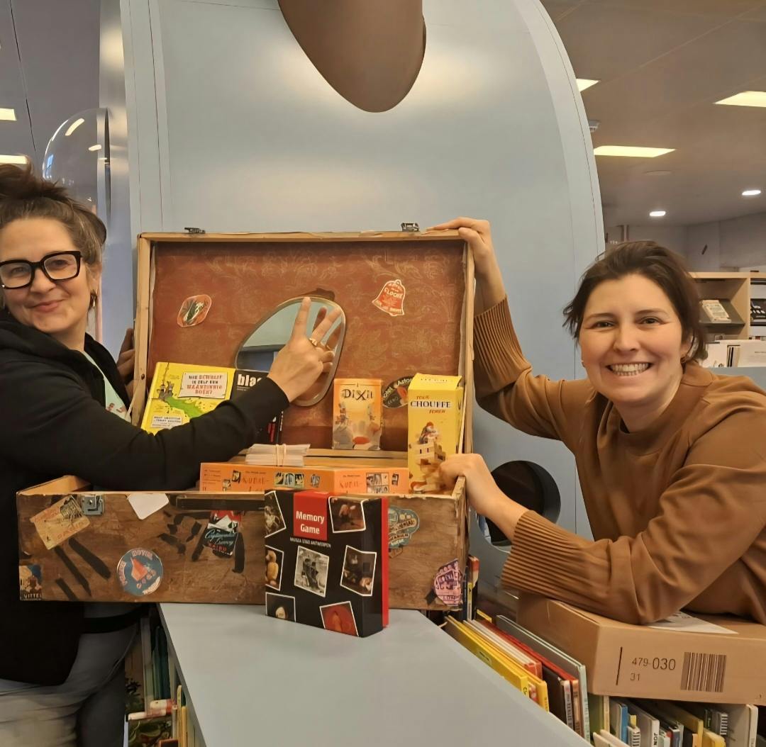 twee bibmedewerkers met een spelletjeskoffer