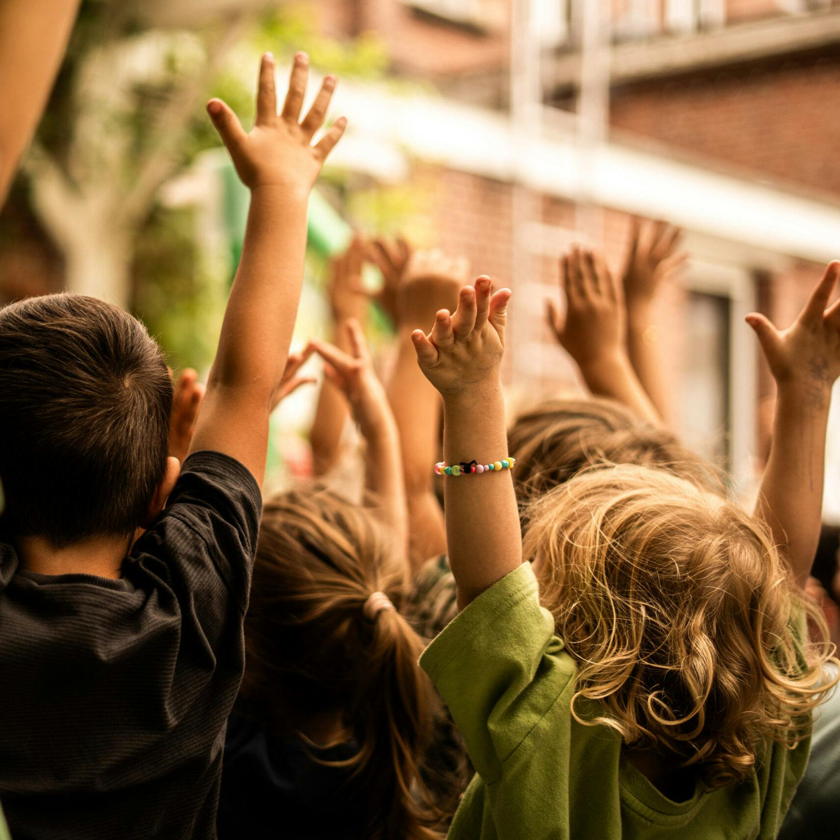Kinderen met hun handen in de lucht