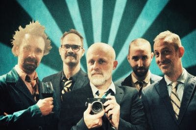 portret van de muzikanten in pak met gestreepte das, een heeft een glas wijn in de hand, een een camera