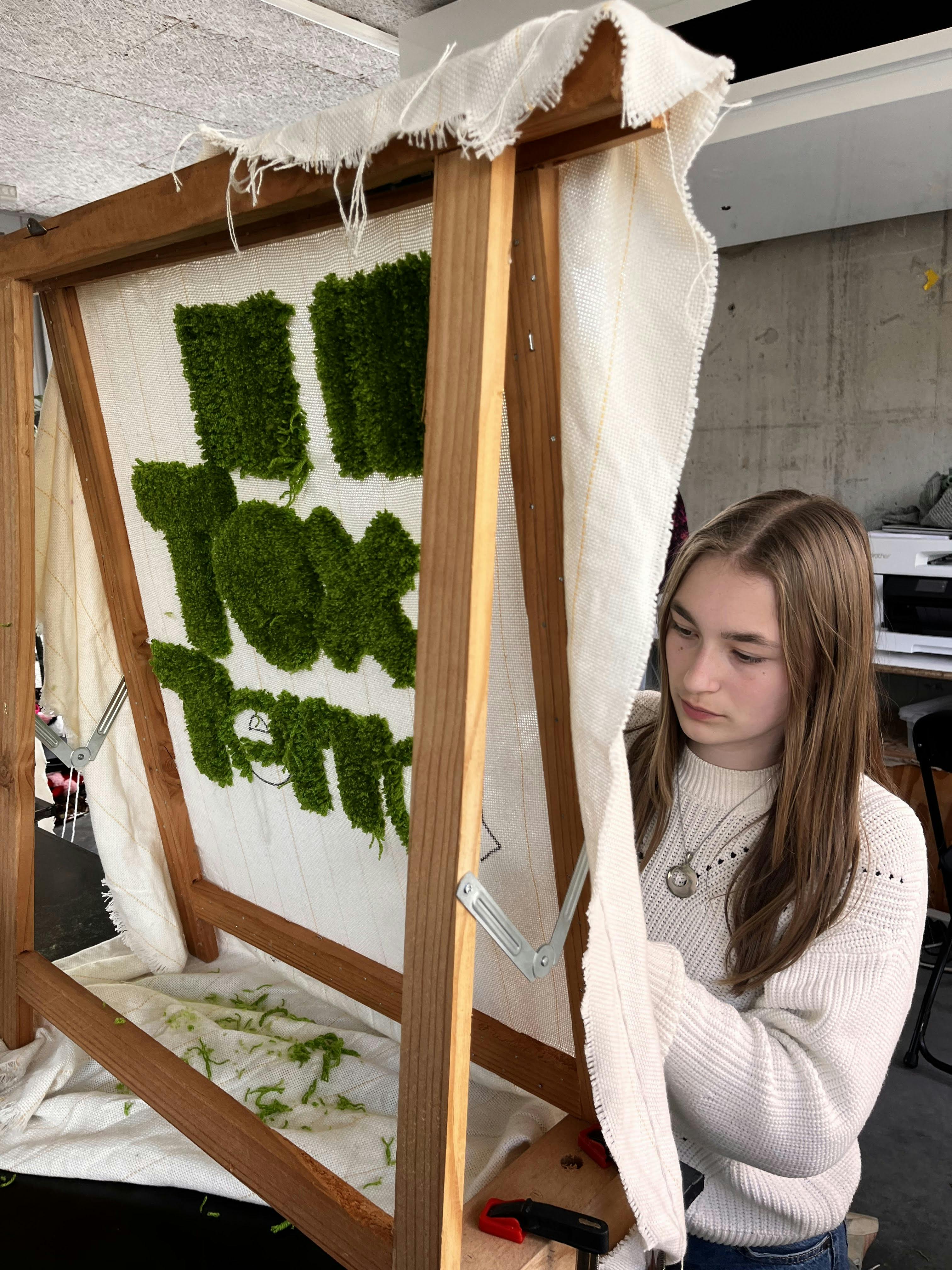 meisje werkt aan een tuft tapijt