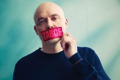 portret van Philippe Geubels met roze sticker met het woord TABOE over zijn mond geplakt