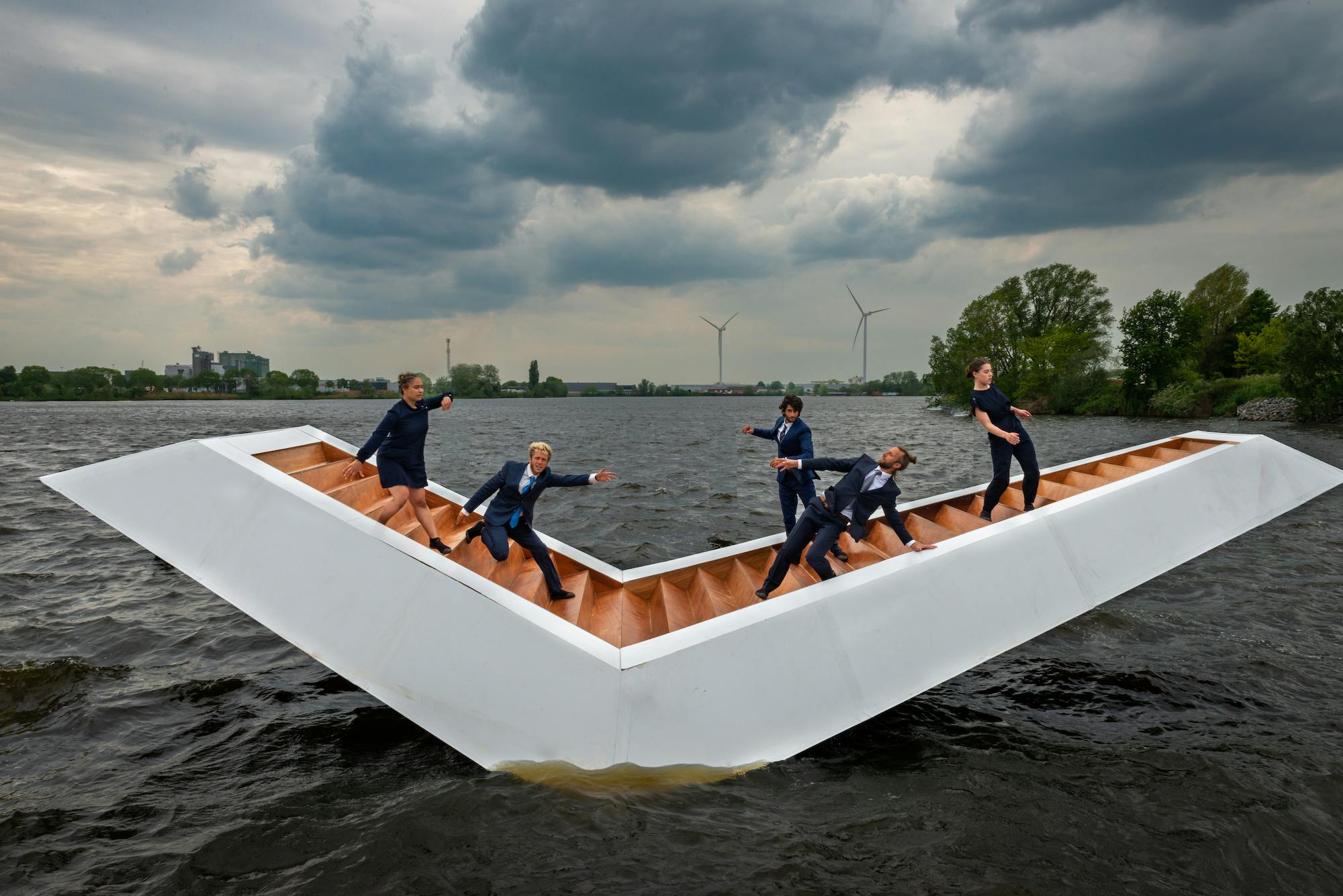 Vijf acrobaten op een schommelende trap op het water