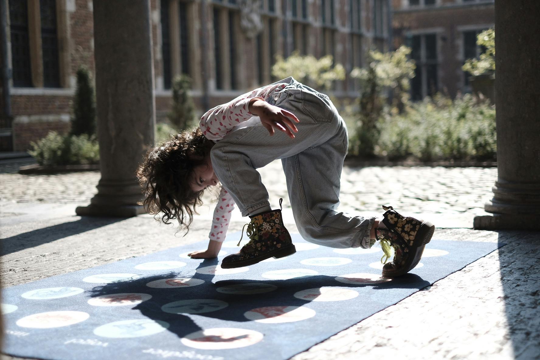 Een kind speelt twister in de binnentuin van het Museum Plantin-Moretus